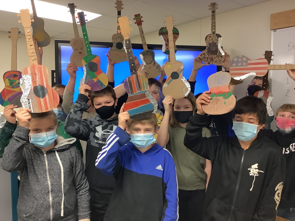 students holding cardboard guitars